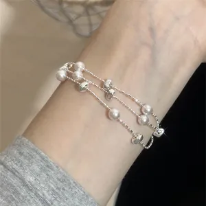 Nahaufnahme eines raffinierten mehrlagigen Armbands mit Perlen und silbernen Perlen