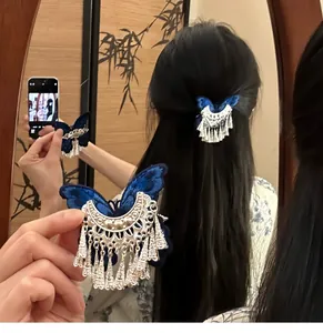 Close-up of vintage blue butterfly hair clip with silver tassels on long dark hair