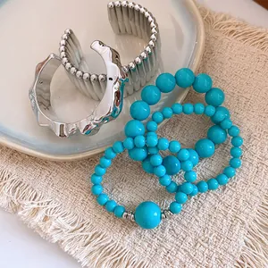 Detailed shot of Bohemian acrylic beaded bracelets and silver cuff bracelets.