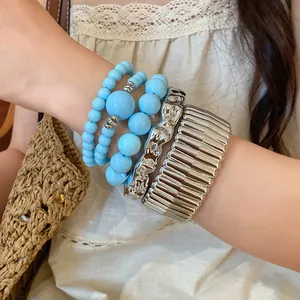 Detail view of bohemian stackable bracelet set featuring blue beads and silver bangles