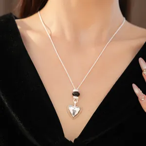 Vue détaillée d'un collier à pendentif cœur facetté mat avec perles en pierre.