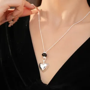 Gros plan détaillé du collier pendentif cœur géométrique avec finition mate et perles