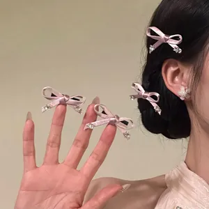 Close-up of pink velvet bow hair clips with crystal details worn by a model