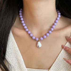 Macro view of lavender acrylic bead necklace with baroque pearl pendant