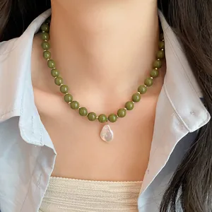 Olive green acrylic bead necklace with baroque pearl pendant on model neck