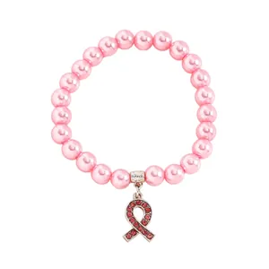 Close-up of pink pearl bracelet with rhinestone breast cancer ribbon charm