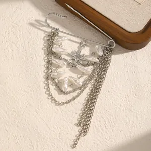 Detailansicht einer eleganten silbernen Quastenbrosche mit Sternanhänger und weißen Perlen
