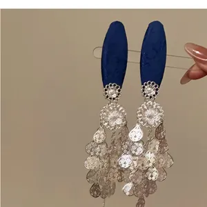 Detail shot of New Chinese style hair clip with blue fabric and silver tassels.