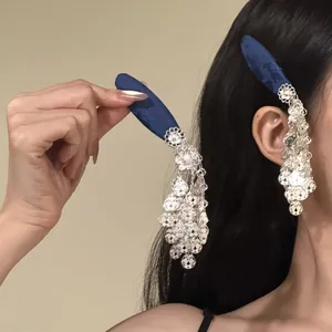 Detailed close-up of blue fabric BB clip featuring an ornate silver floral tassel drop