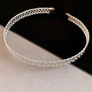 Dettaglio macro del girocollo in metallo intrecciato argento con un elegante motivo a croce