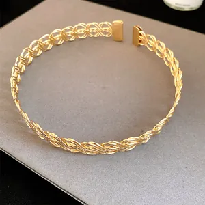 Primo piano di un girocollo in metallo intrecciato dorato con un elegante design aperto