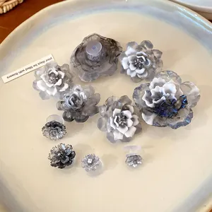 Detailed view of monochrome resin flower shoe charms with artistic gradient ink effect