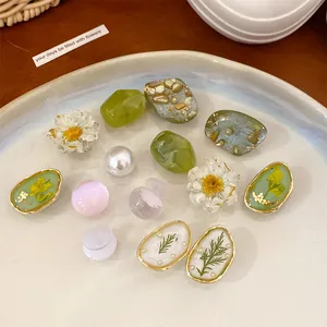 Detail view of colorful resin flower and stone shoe charms in a decorative dish
