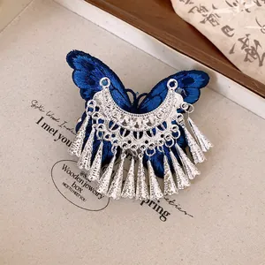 Primo piano di un fermaglio per capelli a farfalla blu vintage con nappe d'argento.