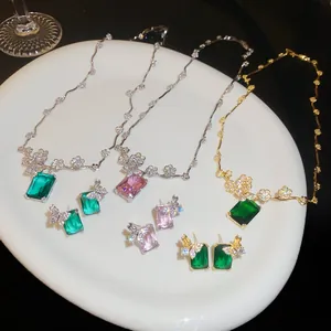 Dettaglio dei set di gioielli con fiori in zircone e pietre taglio smeraldo verde e rosa