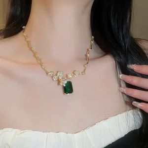 Primo piano di una lussuosa collana placcata in oro 18 carati con pietra verde e zirconi