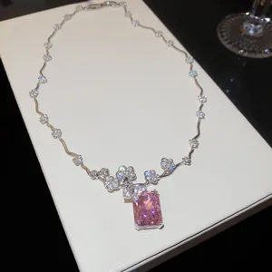 Primo piano della collana con zircone rosa e raffinati dettagli floreali su scatola bianca.