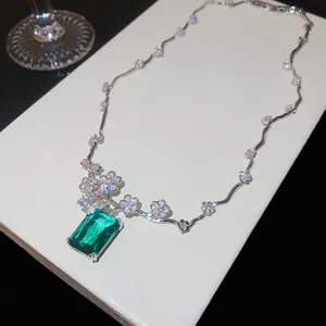 Dettaglio della collana di lusso con zircone verde smeraldo e accenti floreali.