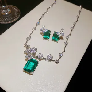 Dettaglio di un set di gioielli di lusso con pietre verde smeraldo e motivi floreali