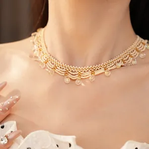 Detailed view of a vintage palace-style cream beaded choker with drop pendants.
