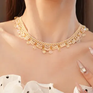 Detailed view of a vintage cream beaded choker with glass drops on a model's neck.