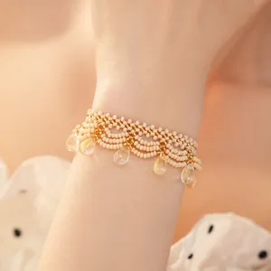 Detailed close-up of a vintage beaded lace bracelet with clear teardrop glass charms.