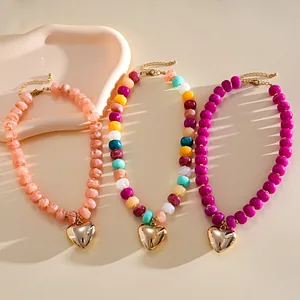 Detail of dopamine-style acrylic marbled bead necklaces featuring gold heart charms