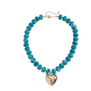 Vibrant blue marbled acrylic bead necklace featuring a polished large gold heart pendant