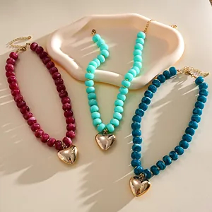 Detail of three dopamine-style acrylic marbled bead necklaces with gold heart pendants.