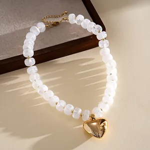 Close-up of a marbled acrylic bead necklace with a shiny gold heart pendant detail.