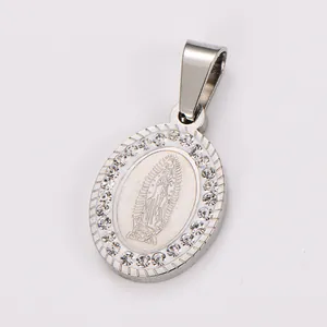 Detailed view of a vintage oval stainless steel religious pendant with rhinestone border