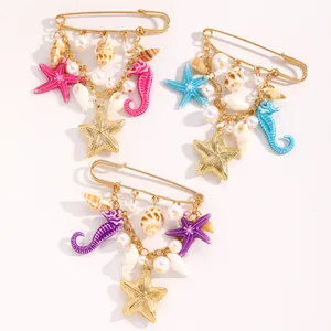 Gros plan de broches colorées d'étoiles de mer et d'hippocampes avec perles et coquillages.