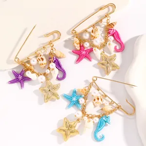 Vue détaillée de broches de plage avec étoiles de mer, coquillages et perles.