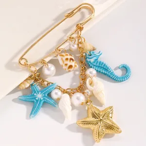 Detailed view of marine-style gold brooch featuring starfish, seahorse, and pearl charms