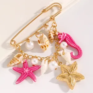 Detailed view of ocean-themed brooch with starfish, seahorse and seashell charms.