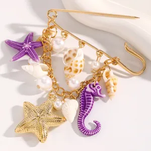 Detailed view of nautical safety pin brooch with starfish, seahorse, and shell charms