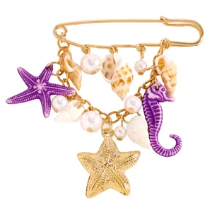 Détail de la broche thème océan avec charms étoile de mer, hippocampe et coquillages