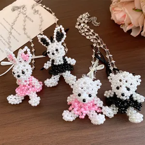 Détail des pendentifs d'ours et de lapin en perles avec une fine chaîne ornée de cœurs