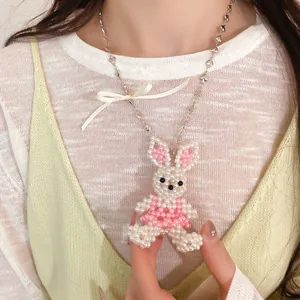 Gros plan d'un collier lapin en perles fait main orné d'un délicat nœud en ruban satiné