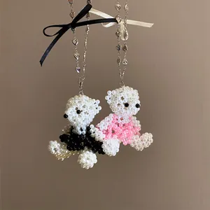 Détail de colliers ours en perles faits main avec chaînes cœur et rubans.