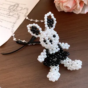 Détail exquis d'un collier avec pendentif lapin en perles noires et blanches fait main et un nœud