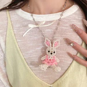 Détail en gros plan d'un pendentif lapin en perles avec un nœud en ruban crème doux