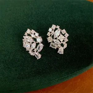 Detalle macro de elegantes pendientes de racimo plateados con circonias muy brillantes