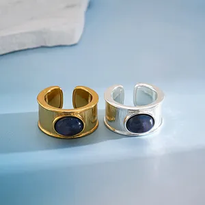 Detalle de anillos abiertos bañados en oro de 18k y plata con piedra de resina azul veteada.