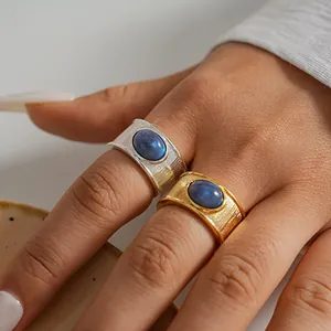 Primer plano de anillos retro de oro y plata con incrustación de resina azul en la mano.