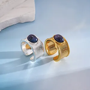 Primer plano de anillos de metal texturizados vintage con incrustaciones de resina azul.