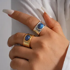 Vista detallada de anillos anchos bañados en oro de 18k y plata con piedra de resina azul