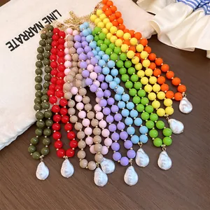 Detail of colorful acrylic bead necklaces with irregular pearl pendants in various shades.