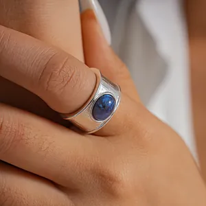 Primer plano detallado de un anillo texturizado chapado en oro 18k con resina azul veteada