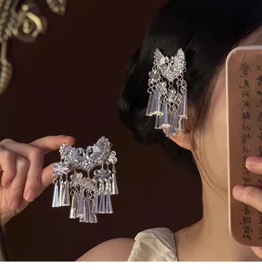 Vue détaillée de la pince à cheveux papillon argentée vintage avec glands en métal.
